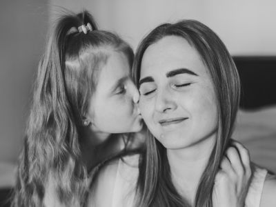 A mother smiles; positive parenting tips helped her cope with the mental load.