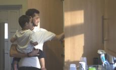 dad carrying child in kitchen