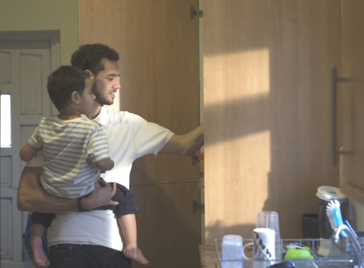 dad carrying child in kitchen
